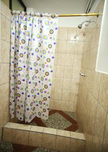 y baño con ducha y cortina de ducha. en Hostal Bavaria de la Alameda, en Quito
