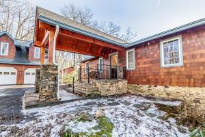 ブーンにあるStone Ridge Lodgeの地面に雪が積もった屋根付きのポーチのある家