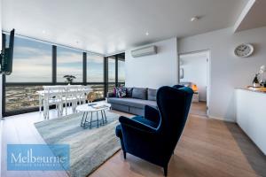 Melbourne Private Apartments - Collins Street Waterfront, Docklands في ملبورن: غرفة معيشة مع أريكة وطاولة