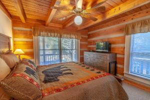 Dormitorio con cama y TV en una cabina en Sugar Shack, en Banner Elk