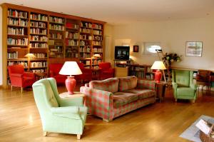 a living room with a couch and chairs and bookshelves at Malteser Kommende in Engelskirchen