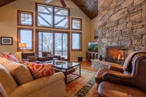 a living room with couches and a stone fireplace at Sunset Lodge in Blowing Rock