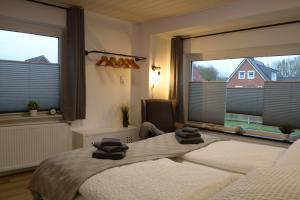 ein Schlafzimmer mit einem Bett und zwei großen Fenstern in der Unterkunft Privatzimmer im Einfamilienhaus in Emden
