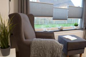 a living room with a chair and a window at Privatzimmer im Einfamilienhaus in Emden