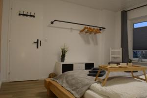 a white bedroom with a bed and a table at Privatzimmer im Einfamilienhaus in Emden