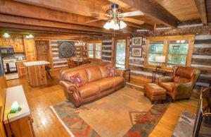 a living room with leather furniture and a ceiling fan at The Berry Patch in Blowing Rock