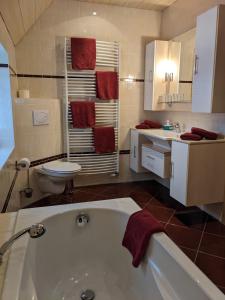ein Badezimmer mit einer Badewanne, einem WC und einem Waschbecken in der Unterkunft Pension Auf der Tenne in Klöden