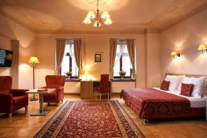 Habitación de hotel con cama, sillas y ventanas en Hotel Santi, en Cracovia