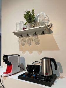 a kitchen counter with a coffee maker and a shelf at دخول ذاتي - غرفة نوم وصالة جلوس (هادئة وخصوصية عالية) in As Sayl aş Şaghīr