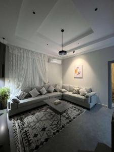 uma sala de estar com um sofá e uma mesa em دخول ذاتي - غرفة نوم وصالة جلوس (هادئة وخصوصية عالية) em As Sayl aş Şaghīr