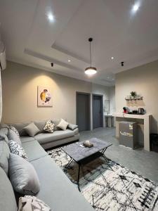 uma sala de estar com um sofá e uma mesa em دخول ذاتي - غرفة نوم وصالة جلوس (هادئة وخصوصية عالية) em As Sayl aş Şaghīr