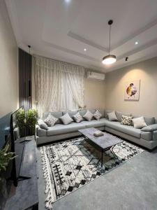 sala de estar con sofá y mesa en دخول ذاتي - غرفة نوم وصالة جلوس (هادئة وخصوصية عالية) en As Sayl aş Şaghīr