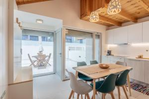 a kitchen and dining room with a wooden table and chairs at Apartamento Férias (Apartamento Sul) in Gafanha da Encarnação +14 photos