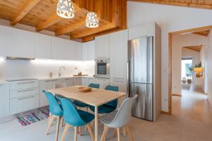 a kitchen with a wooden table and blue chairs at Apartamento Férias (Apartamento Sul) in Gafanha da Encarnação
