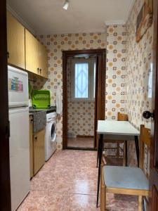 cocina con nevera, mesa y ventana en Alex Apartment, en Valencia