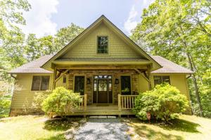 a small yellow house with a porch at The Ponderosa in Boone