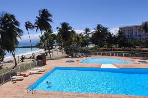 a swimming pool with a view of the beach at Parfum des îles - vue mer, plage à 30m et piscine en option in Le Gosier