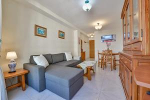 ein Wohnzimmer mit einem Sofa und einem Tisch in der Unterkunft Villas Guzman - Apartamento Apolo XI in Calpe