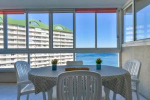 a dining room with a table and chairs and windows at Villas Guzman - Apartamento Apolo XI in Calpe