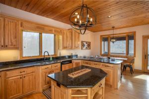 a kitchen with wooden cabinets and a black counter top at Villa Costalotta in Sugar Mountain +48 photos