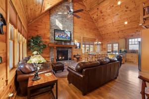 a living room with leather furniture and a fireplace at Valle Crucis Overlook in Banner Elk