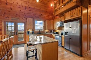 a kitchen with wooden cabinets and a stainless steel refrigerator at Valle Crucis Overlook in Banner Elk