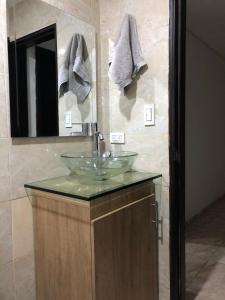 a bathroom with a sink and a mirror at Acogedor alojamiento con piscina cerca al mar! in Gaira