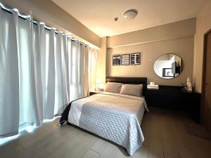 a bedroom with a bed and a large window at Cozy condo near Airport Manila in Manila