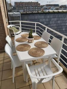 un tavolo bianco e sedie sul balcone di Sea & the City a Blankenberge