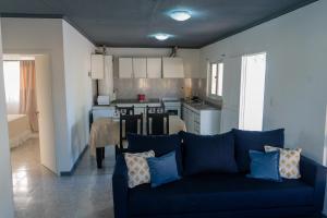 sala de estar con sofá azul y cocina en Amplio, Verde y Privado. en Mendoza