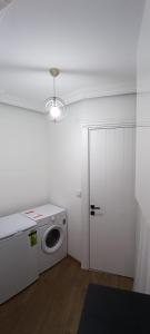 eine Waschküche mit einer Waschmaschine und einer Tür in der Unterkunft Beşiktaş Merkez. in Istanbul