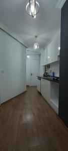 eine große Küche mit weißen Schränken und Holzböden in der Unterkunft Beşiktaş Merkez. in Istanbul