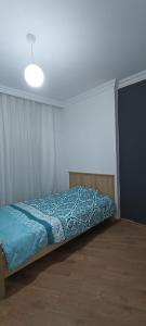 Schlafzimmer mit einem Bett mit blauer Decke in der Unterkunft Beşiktaş Merkez. in Istanbul
