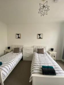 two beds sitting next to each other in a bedroom at Sydenham Place in Forest Hill