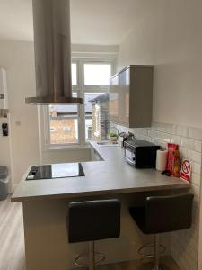 a kitchen with a counter with two bar stools at Sydenham Place in Forest Hill