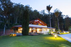 a house with a large yard with a tree at Sítio dos Lagos in Domingos Martins
