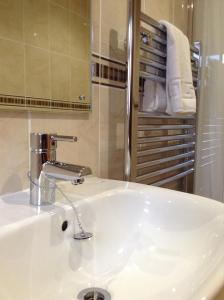 a bathroom with a white sink and a mirror at The Crown Hotel in Mundford