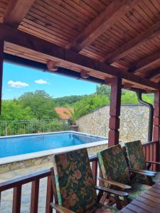 a patio with two chairs and a swimming pool at Pogled Vrdnik in Vrdnik