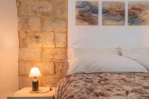 a bedroom with a bed and two paintings on the wall at LA CASA DEI CANDELAI in Siracusa