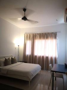 a bedroom with a bed and a window with a table at Free Netflix&WiFi Putrizarreth Skyhouse Kt Town in Kuala Terengganu