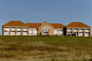 a large building on top of a grass field at GreenLine Hotel Hellfeld in Neubrandenburg
