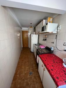 una pequeña cocina con encimera roja en una habitación en Naomi en Mar del Plata