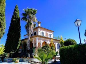 a house with a palm tree in front of it at Casa Villa Las Palmeras in Arriate