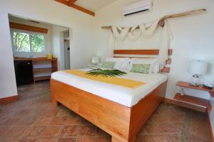 une chambre avec un grand lit dans une pièce dans l'établissement Coral Beach Village Resort, à Utila