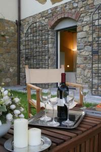 a table with two glasses and a bottle of wine at Il Poggiolo Delle Rose Bed&Breakfast in Tavarnuzze