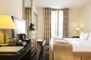 a hotel room with a bed and a desk at Hôtel Vaneau Saint Germain in Paris