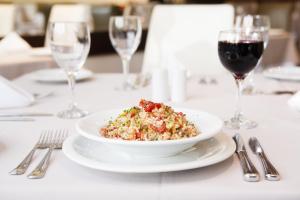 a plate of food on a table with wine glasses at Intercity Porto Alegre Praia de Belas in Porto Alegre +28 photos