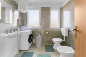 a bathroom with a toilet sink and a washing machine at Apartment MDM in Buje +18 photos