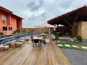 un patio con mesas y sillas junto a una piscina en Condomínio Villamares en Luis Correia