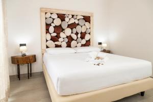 a bedroom with a white bed with a wood headboard at Amaltea in San Severino